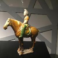 Statuetta femminile a cavallo con scialle di seta sulle spalle, in ceramica a tre colori