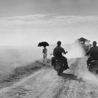 Dei motociclisti e una donna percorrono la strada da Nam Dinh a Thai Binh, Indocina (Vietnam), maggio 1954