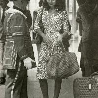 Diane indossa un wrap dress a stampa per una pubblicità di bagagli, 1976 ca.