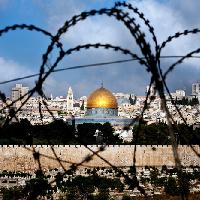 Livio Senigalliesi, Jerusalem on cloudy day through razor wire