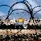 Livio Senigalliesi, Jerusalem on cloudy day through razor wire